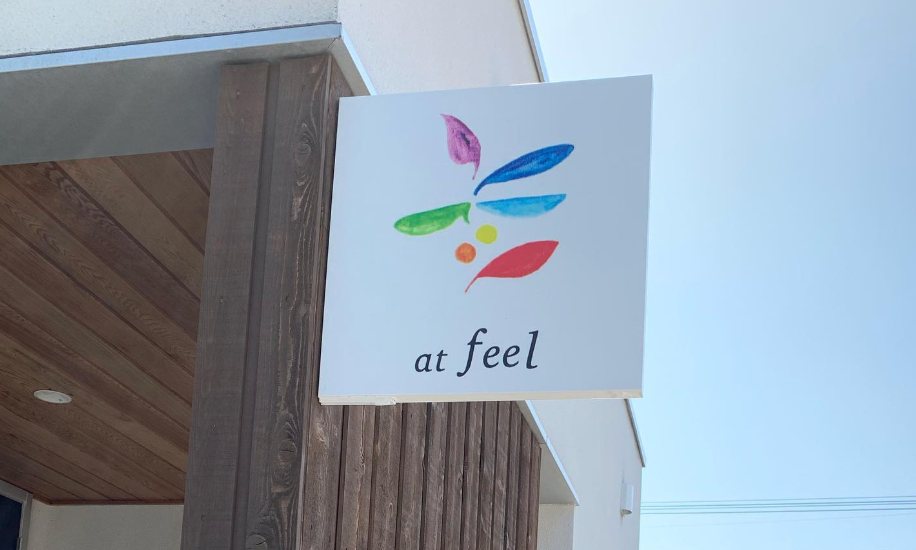 青空を背景にしたat feelのカラフルな看板
